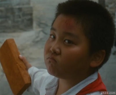 手拿砖头，面露凶相的小男孩