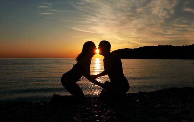 一对恋人在夕阳下摆有趣的造型