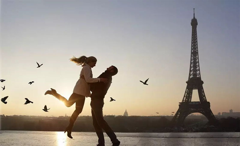 在铁塔边开心得飞起来的情侣