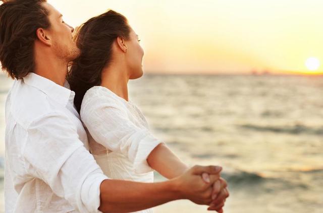 情侣在海边抱着一起看日落