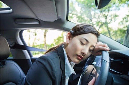 开车累了，爬在方向盘上睡一会