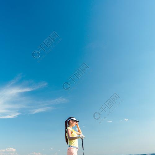 在夏日阳光明媚的日子里 一位身着现代高尔夫服装的健康女性在乡村高
